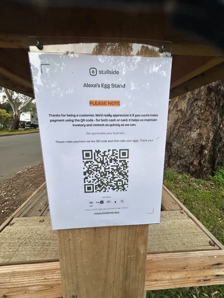 Vendl QR payment poster for Alexa's Egg Stand mounted under the roof of the wooden roadside stall