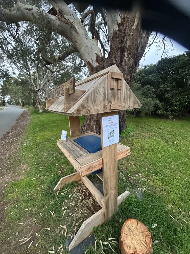 Alexa's roadside egg stand under a large tree, with a Vendl QR payment sign taped to the post